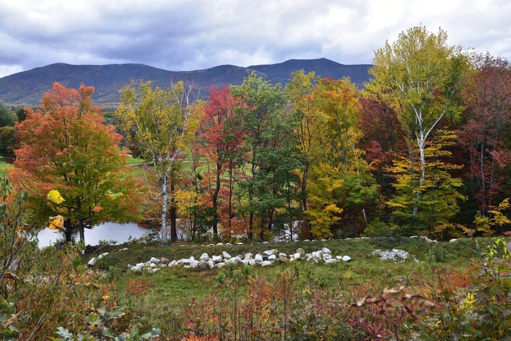 Scenic view of fall foliage with New Hampshire mountains in the distance under a moody grey sky