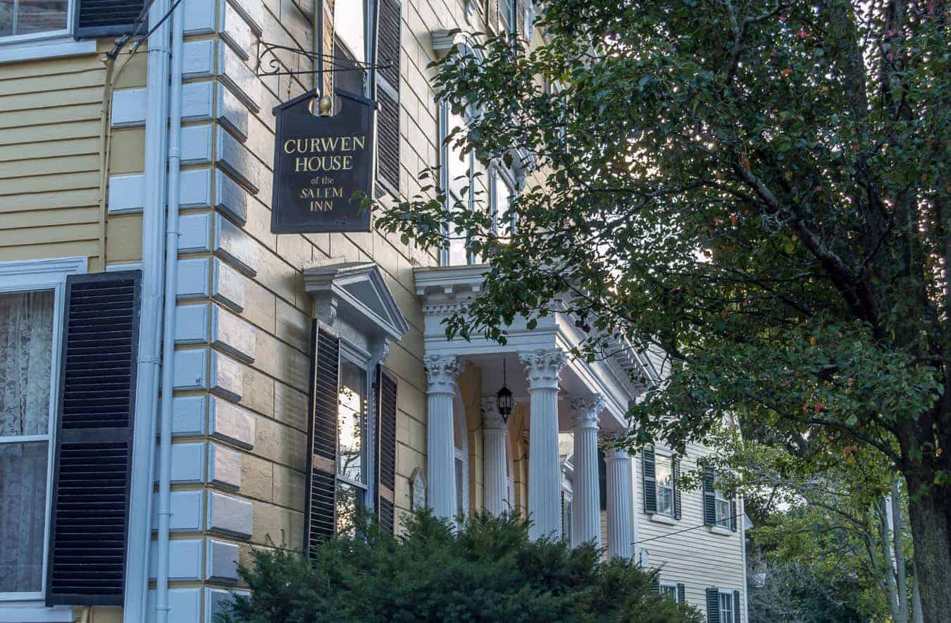 Outside front of white historical building in Salem - black sign reads "Curwen House of the Salem Inn"