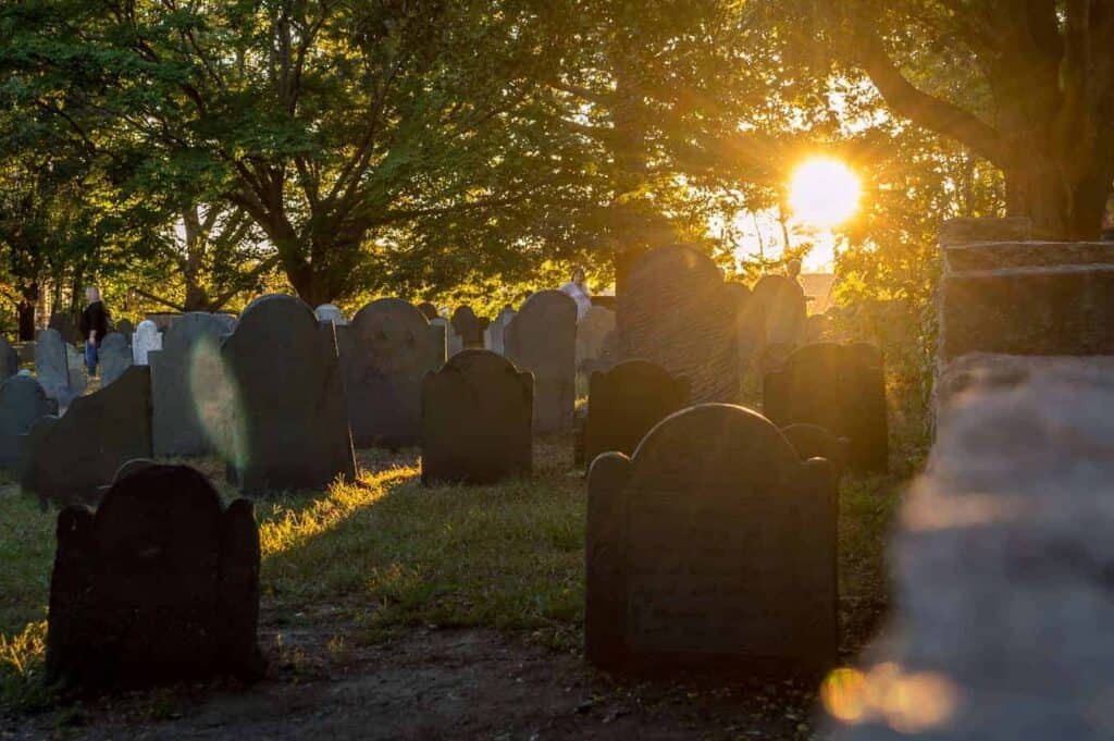 Tombstones in old graveyard at sunset, one of the top things to do in Salem MA in October