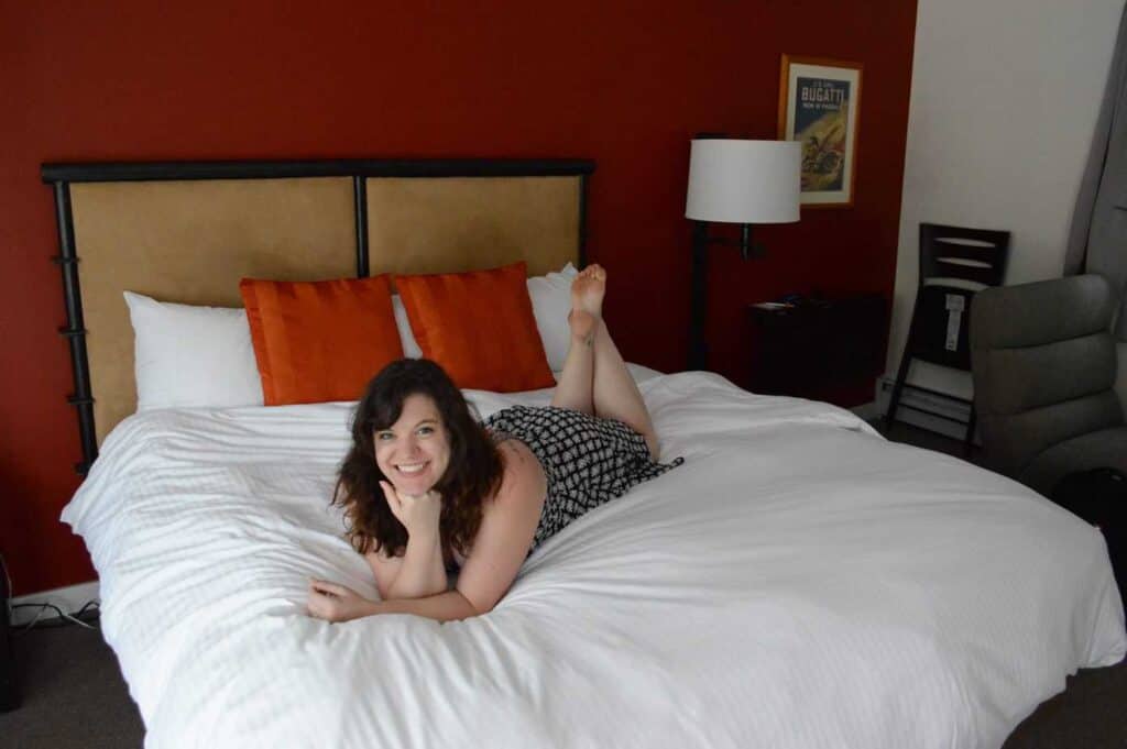 Smiling girl lying on a white bedspread in Woodstock Vermont