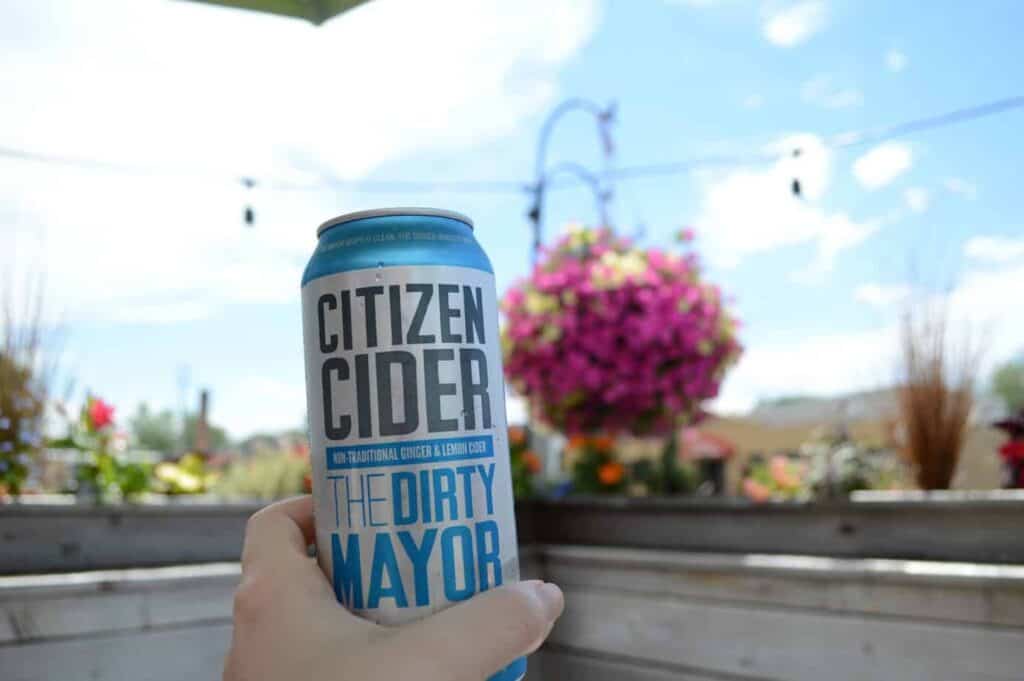 A closeup of a can of Citizen Cider in someone's hand on an outdoor patio in Burlington Vermont
