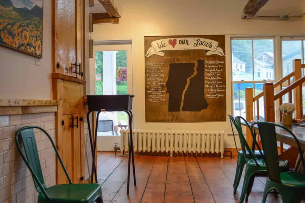 Historic dining room with large map on the wall reading \"We love our locals\" in Woodstock Vermont