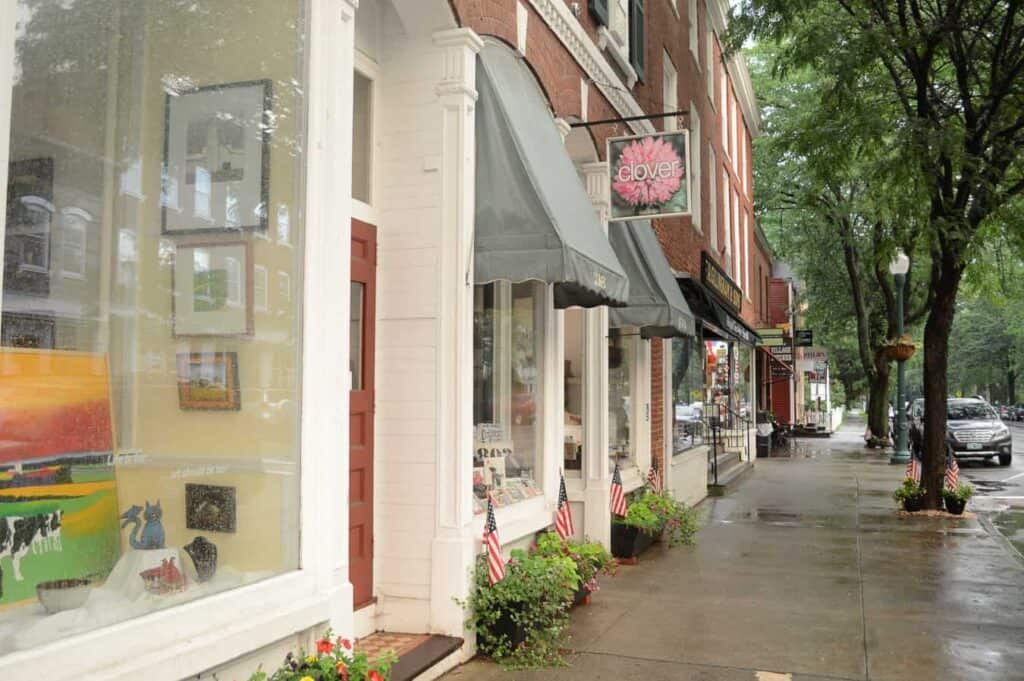 A row of storefronts next to a sidewalk in Woodstock Vermont