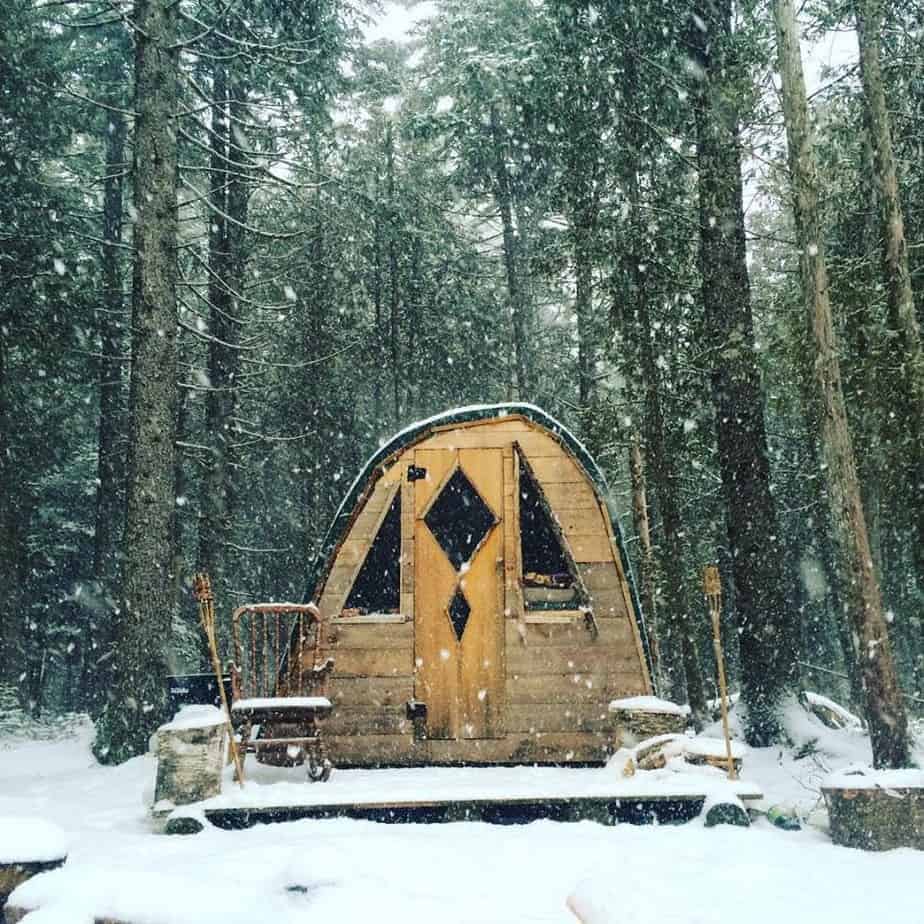 Tent shaped cabin in the snowy woods is a popular off the grid New England vacation rental