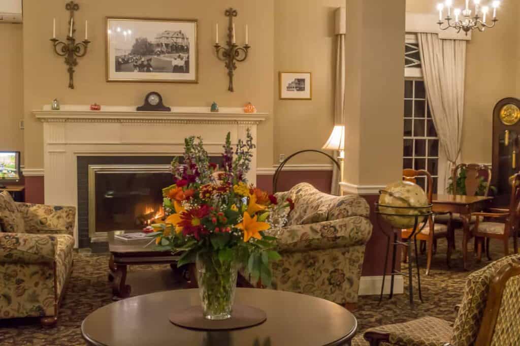 A historic room filled with furniture and vase of flowers on a table.