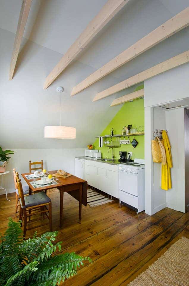 A wooden table with 2 chairs next to a kitchen stove and sink at a Burlington Vermont VRBO