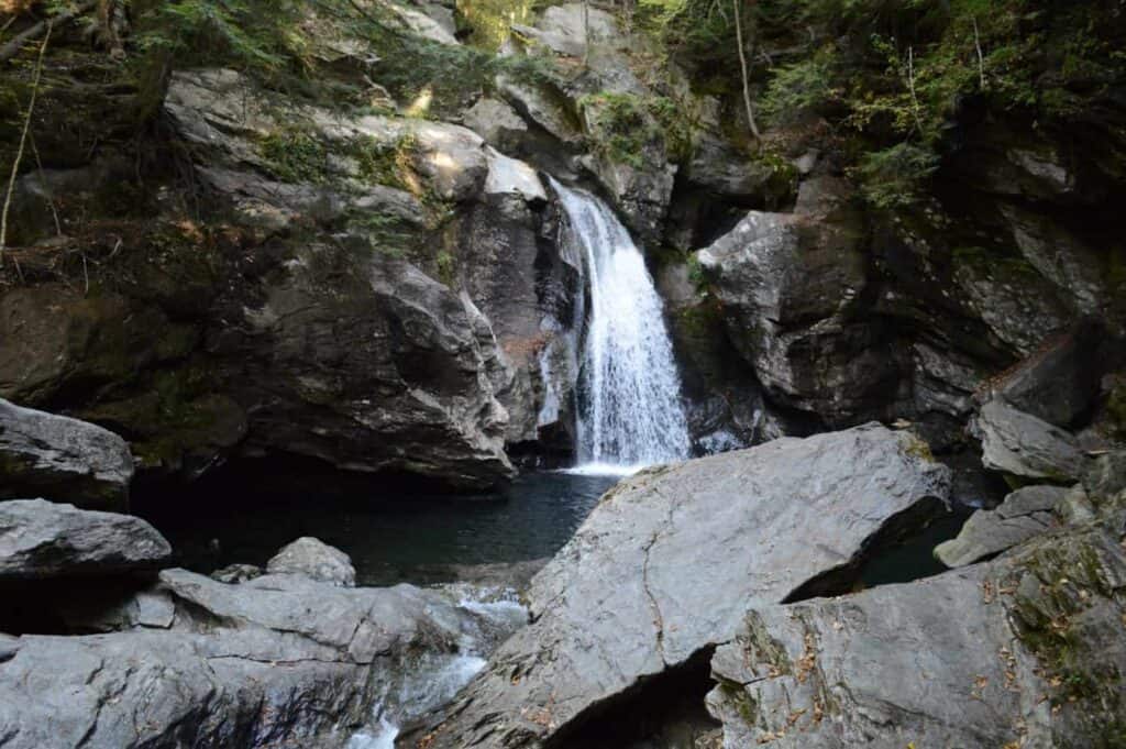 A large waterfall over a rocky area and one of the best places to go in Stowe Vermont