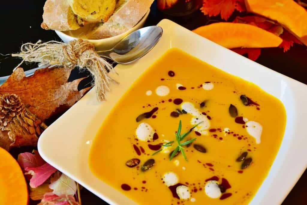 Pumpkin soup in a white bowl being served during autumn in Acadia National Park