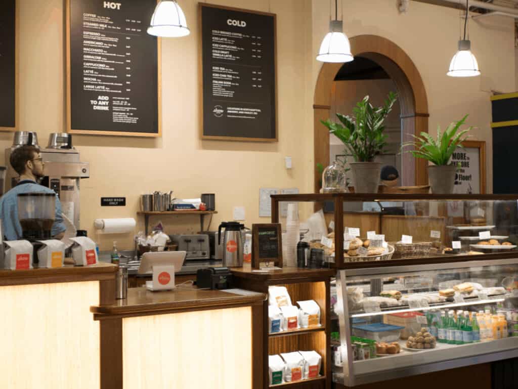 Counter area at a cafe, with ipads set up ready for baristas to check out customers. To the right of the ipads are glass containers with pastries at a Northampton coffee shop.