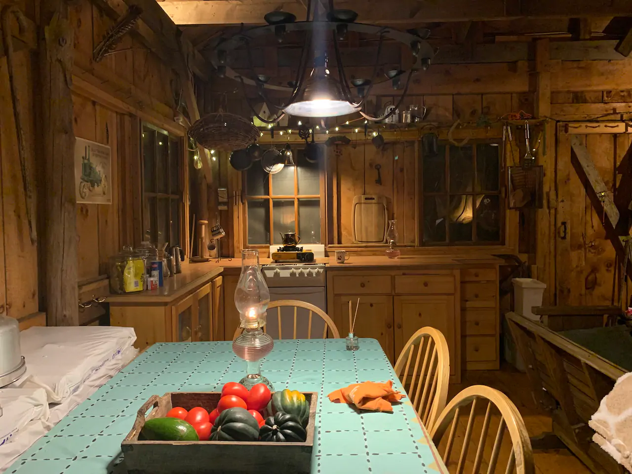 Kitchen table and chairs with a ceiling light and a hurricane lamp on the table