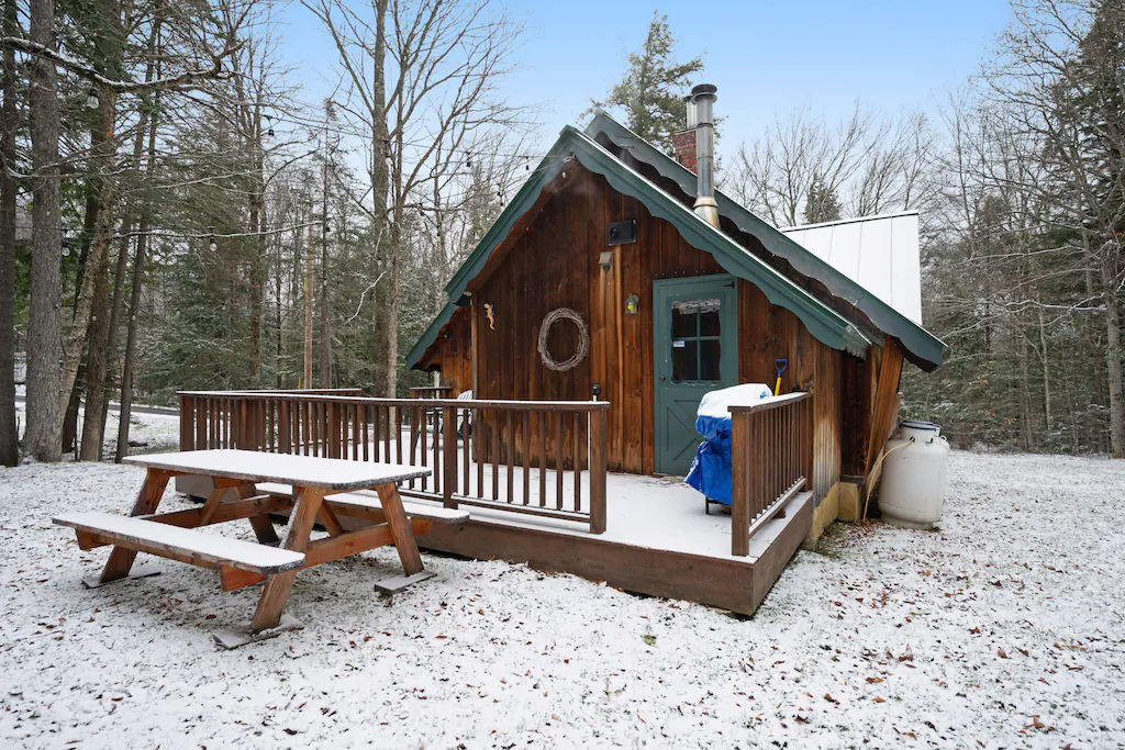 A wooden porch in front of a wooden chalet in the snow in Vermont