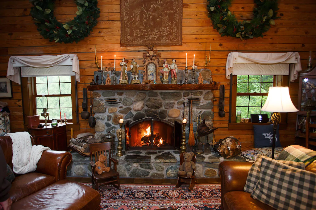 A stone fireplace in a living room with paneled walls