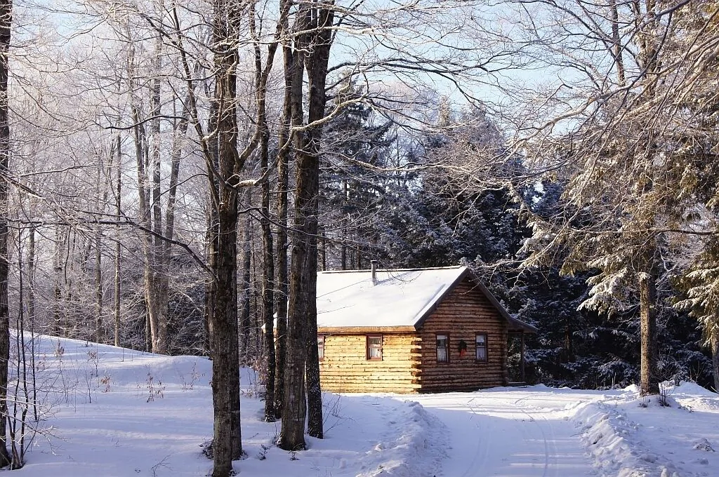 A log cabin in the snowy woods of Vermont