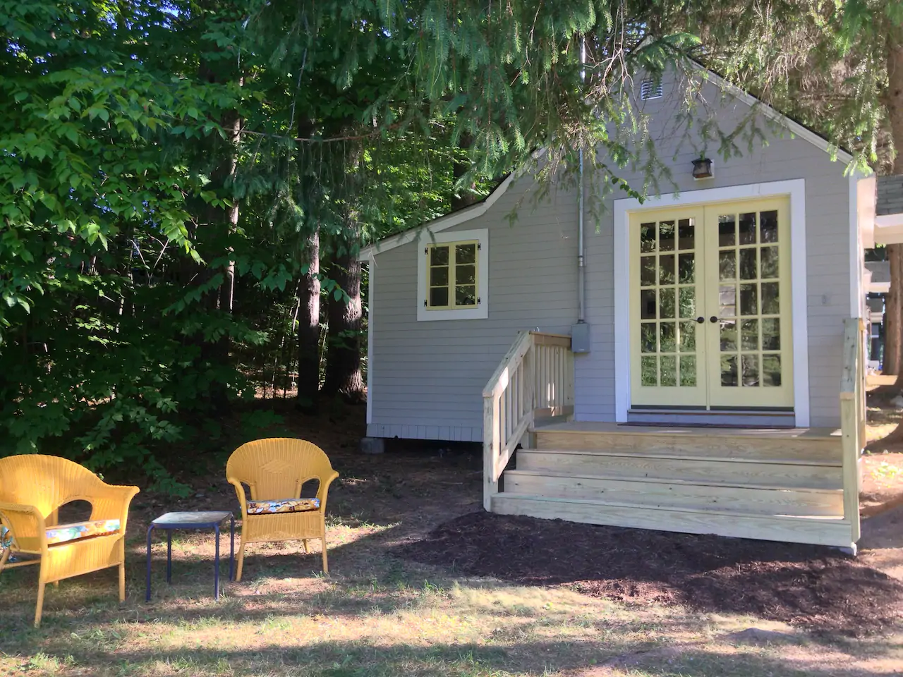 Cabin in the woods with steps leading up to French doors