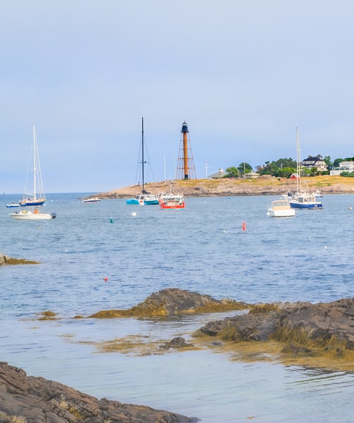 A lighthouse seen in the distance across a body of water