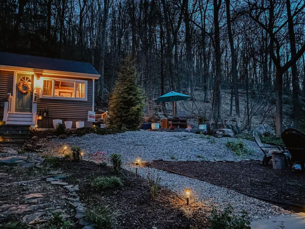 Log cabin Airbnb vacation rental in Connecticut in the woods at dusk