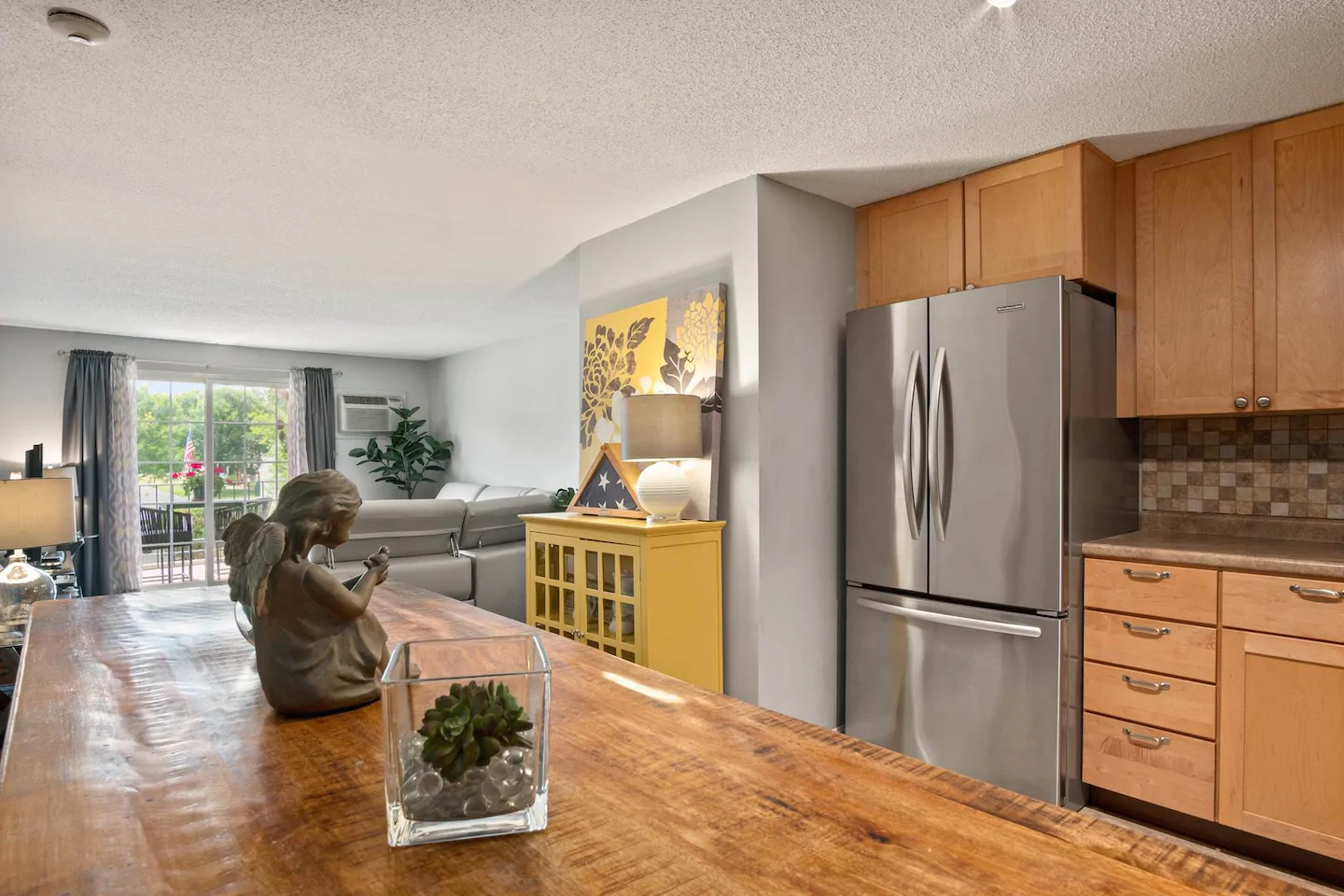 A kitchen with a wooden counter and stainless steel refrigerator