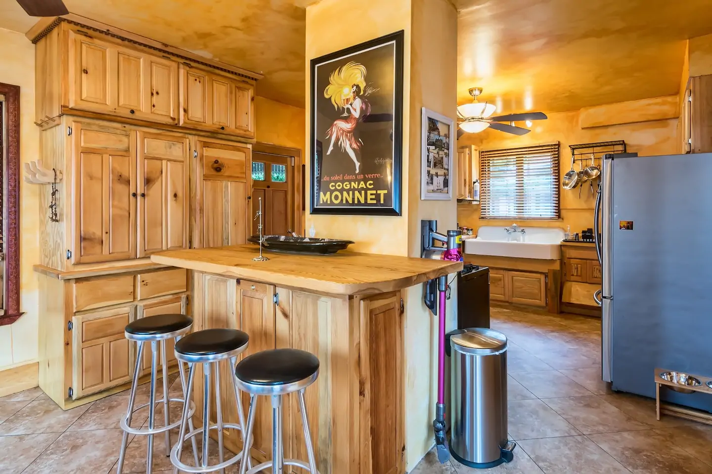 Nicely appointed kitchen with wooden cabinets, island table and bar stools