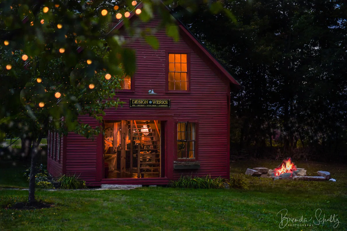 A reddish brown building at dusk with interior lights on