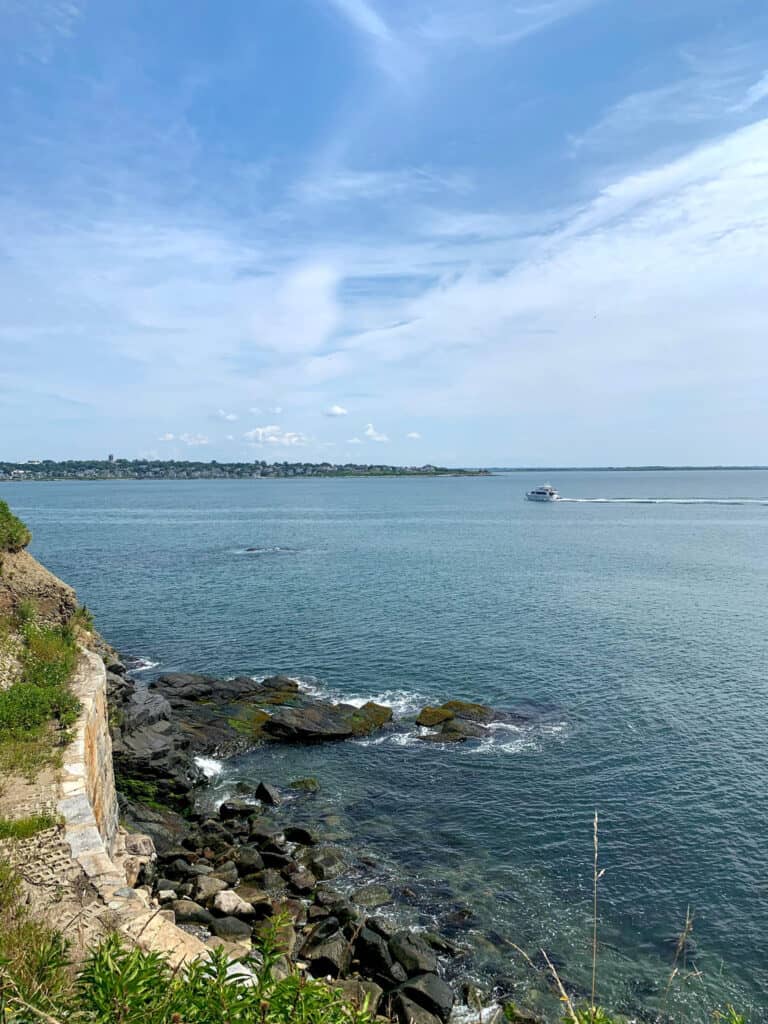 Blue water with land on the left and in the distance under a blue sky