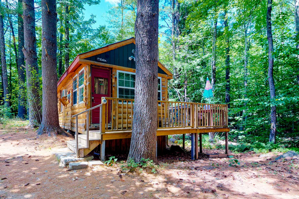 A wooden buildlng with a wooden deck in the woods