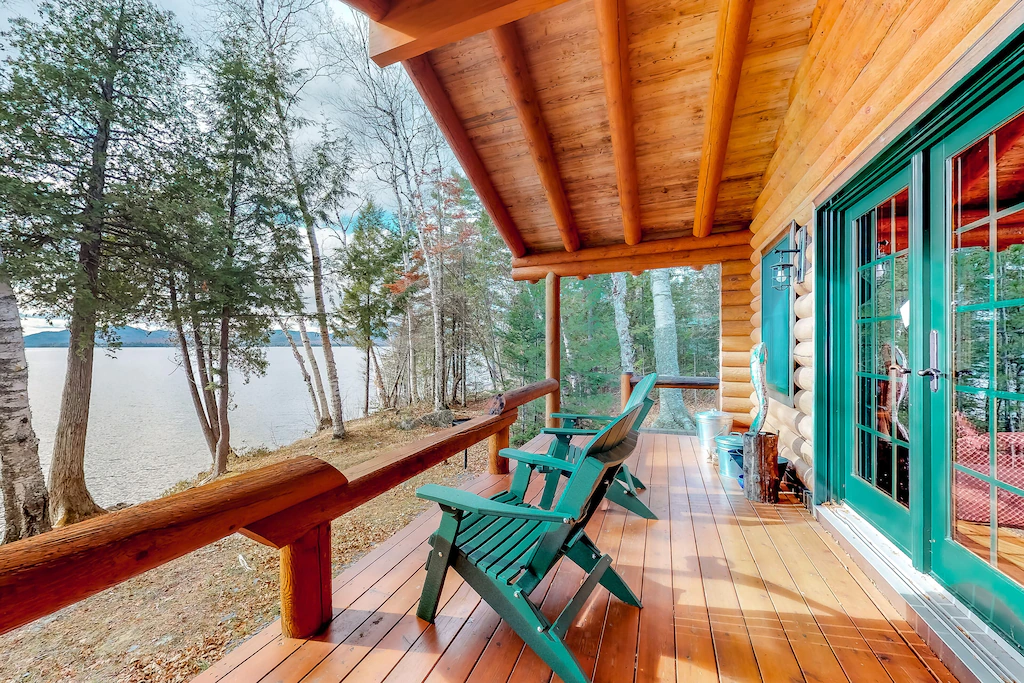 A wooden deck with turquoise colored Adirondack chairs