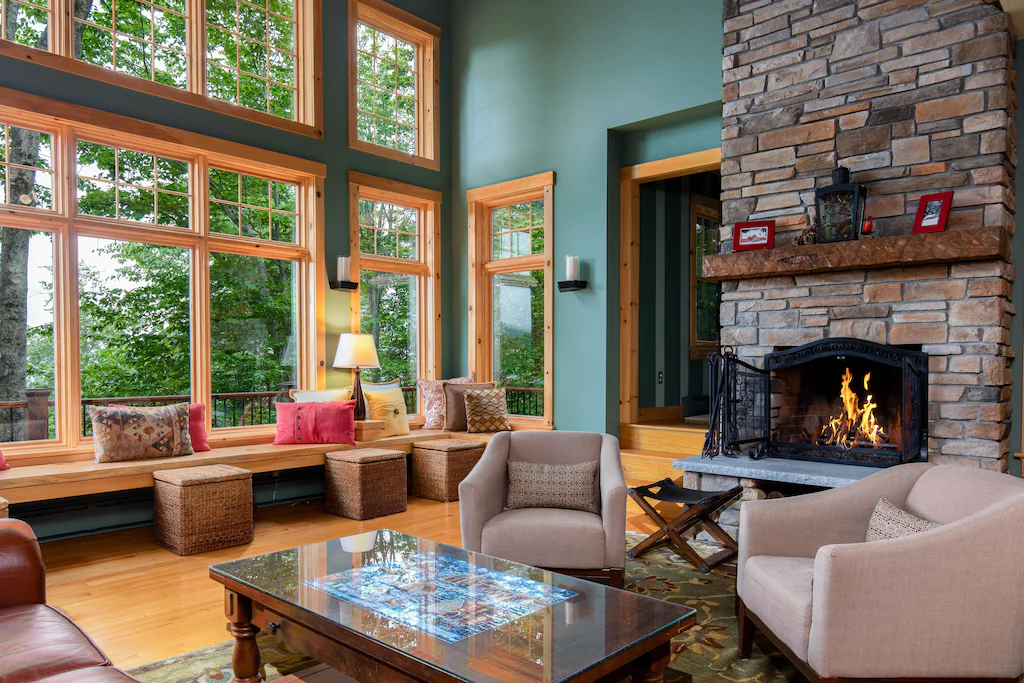 A living room filled with furniture and a lit fire place and open windows