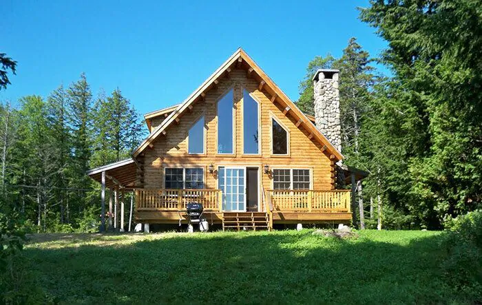 A large lawn in front of a mountain chalet