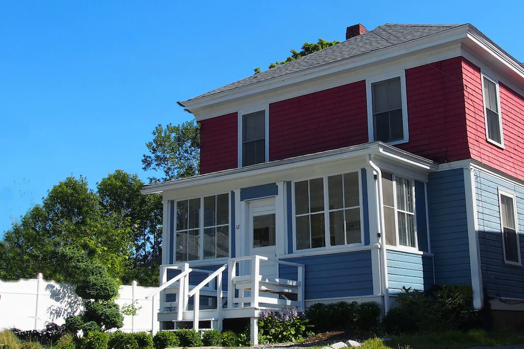 A large brick house with an enclosed porch out front