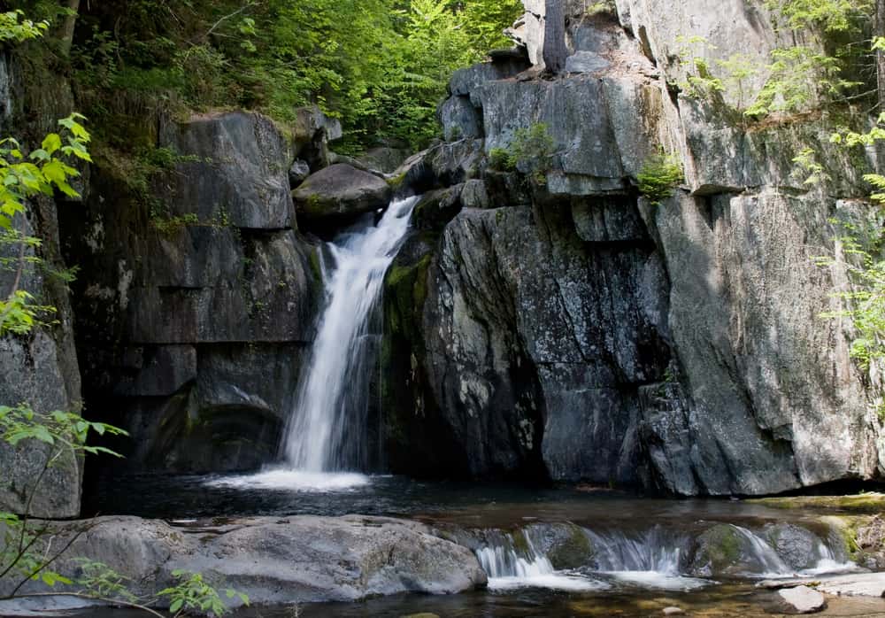 Water leads into a pond as it cascades down rocks.