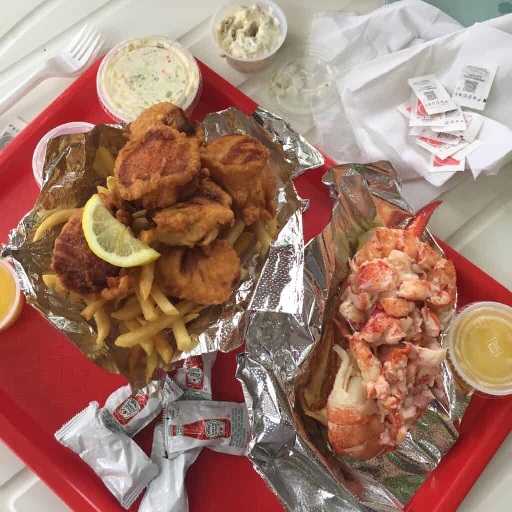 A tray of food on a table, with Seafood and French fries at one of the most iconic Maine lobster pounds