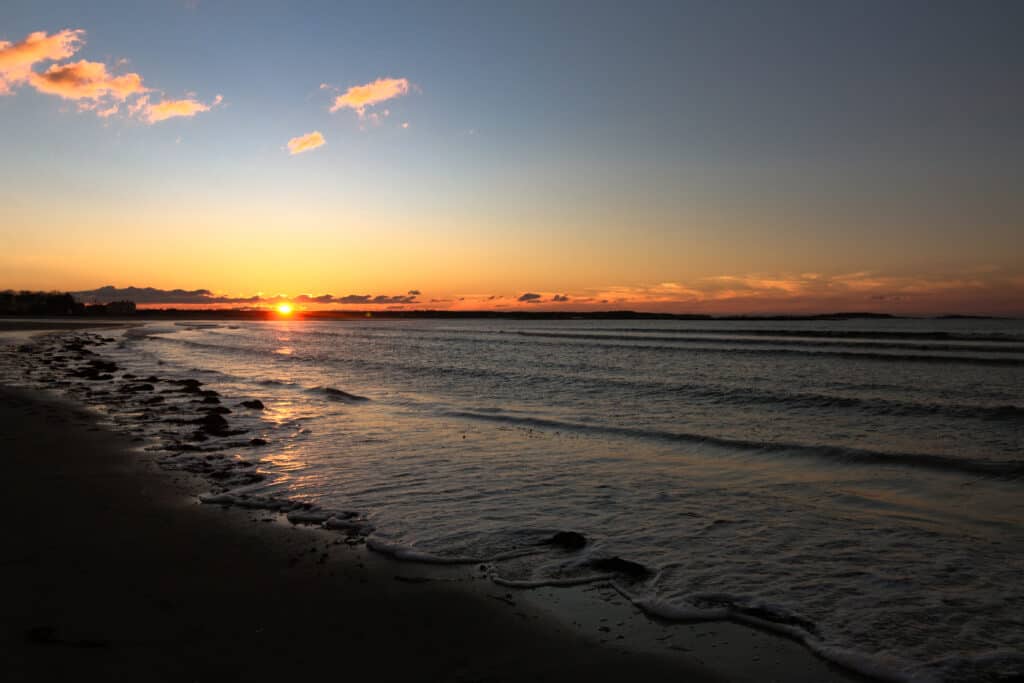 Orange and blue sunset casts over the beach.