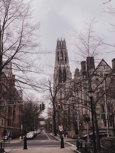 A view of downtown New Haven down a one way street with gothic style buildings on either side on a grey, winter day