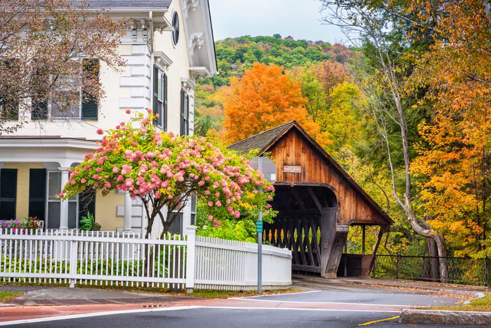 White wooden house next to a covered bridge