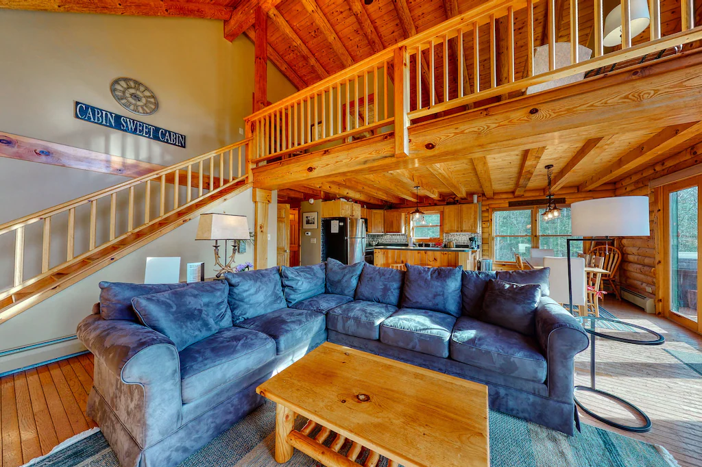 Blue sectional couch in front of steps leading up to a loft at a Franconia vacation rental