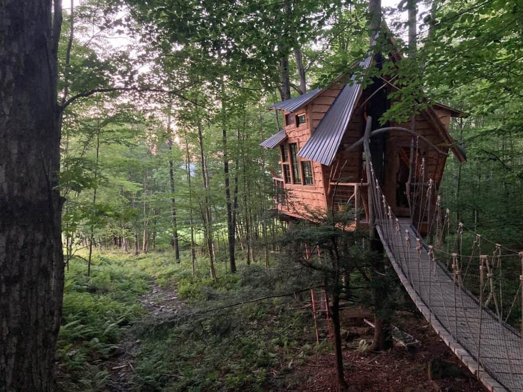 A wooden bridge leading to one of the cutest Airbnb treehouses in New England