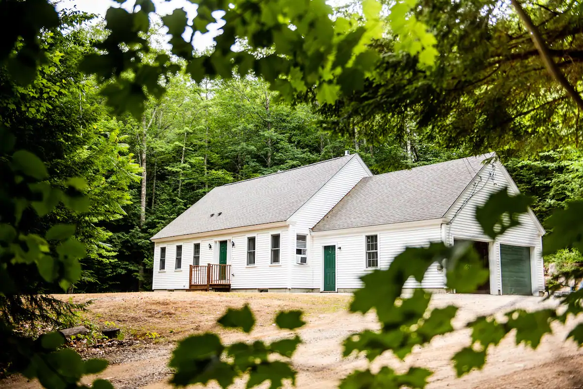 A white building with trees behind it