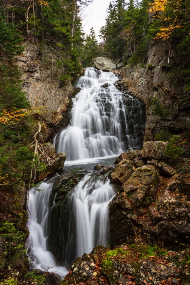 Water surging down rocks into more water surrounded by rocky scenery.