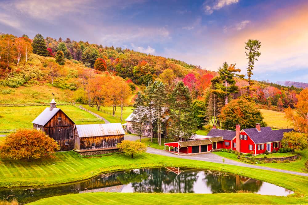 Gorgeous view of the colorful fall mountains behind a farmhouse