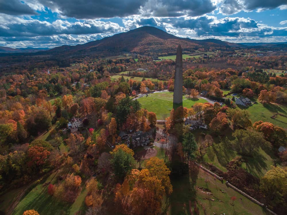 Bennington Monument surrounded by Fall trees and mountains