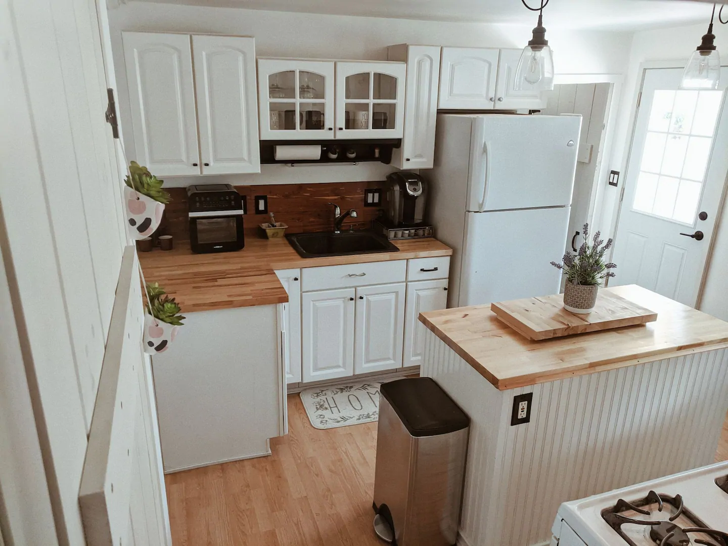 Interior of a kitchen with white cabinets and warm wood accents.