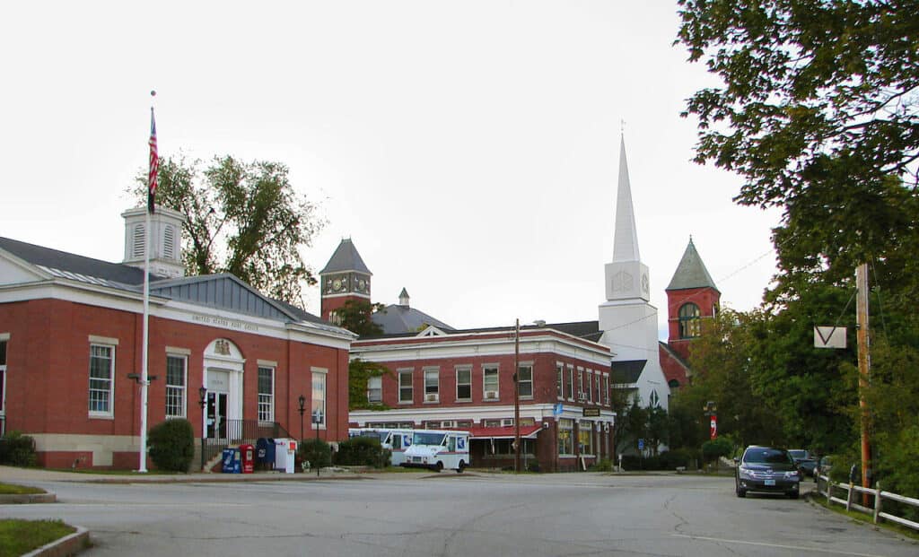 City buildings, a white steeple and a parking lot