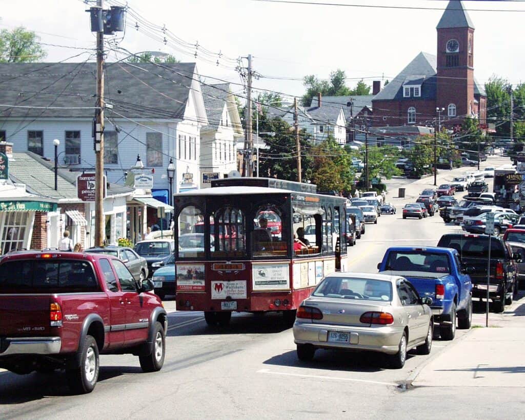 A trolley on the street in the midst of traffic