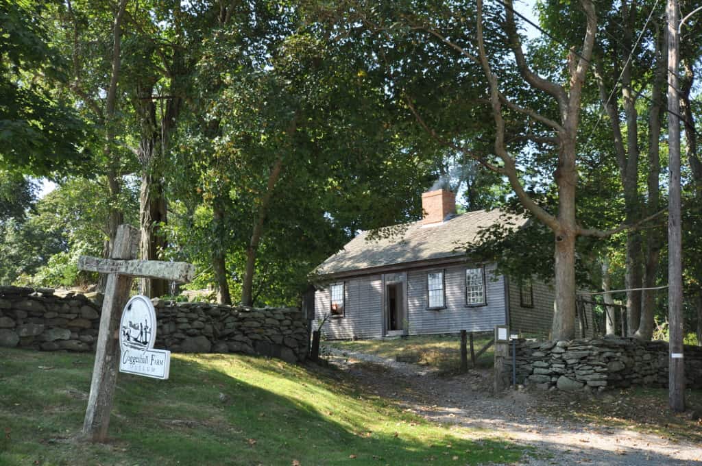 A house with trees in the background and a for sale sign