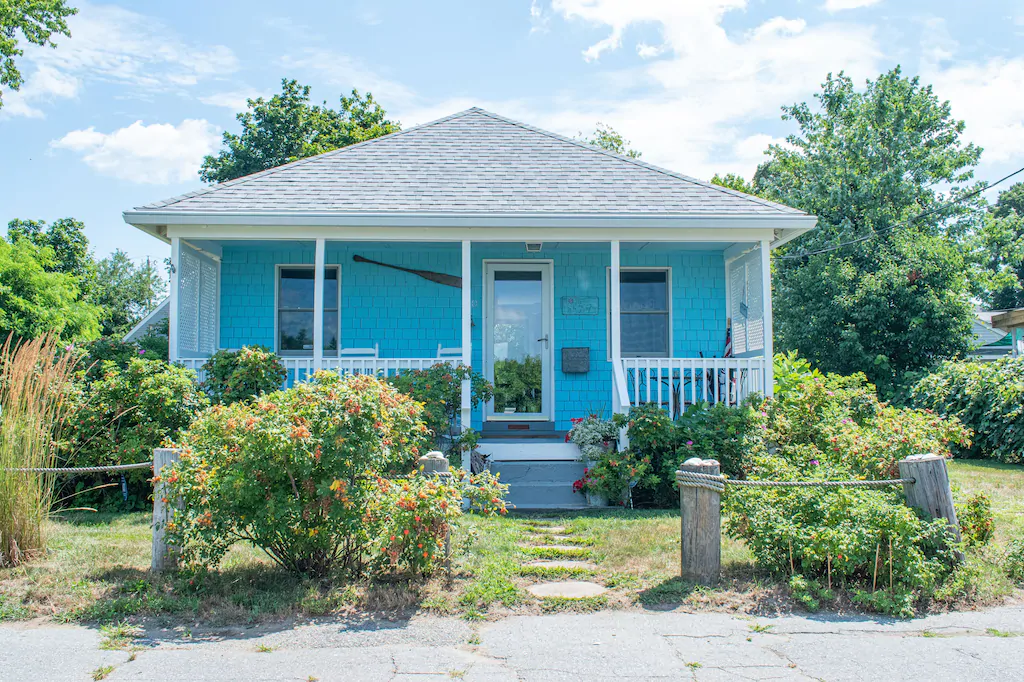 Turquoise house with white roof and porch is one of the cutest vacation rentals in Rhode Island