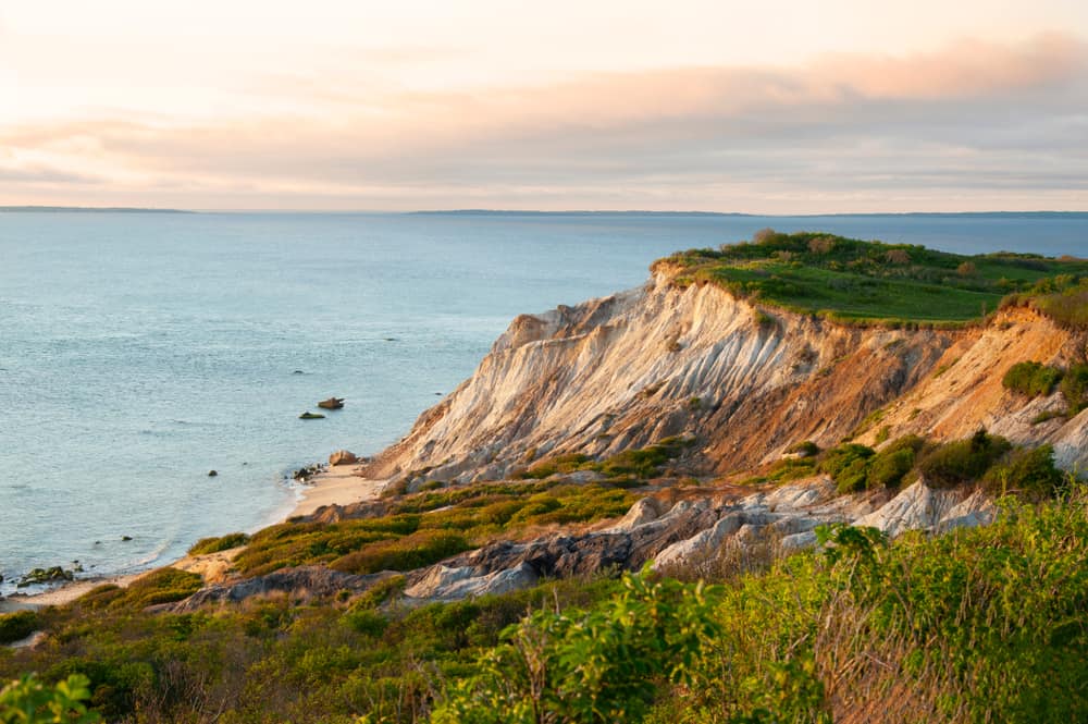 A huge cliff on the seaside under a pink sky