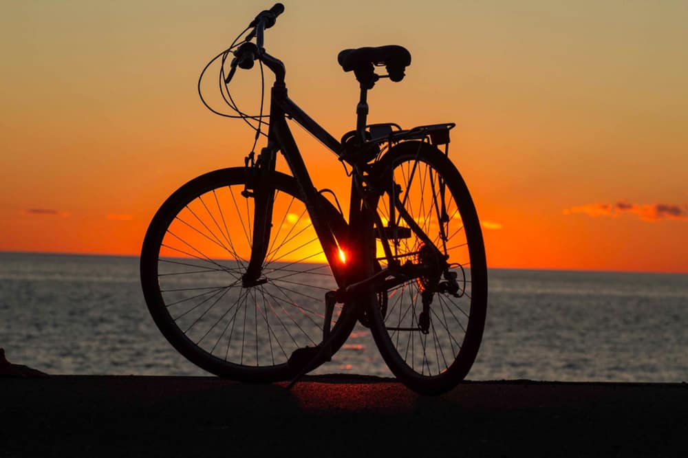 Closeup of an adult bike next to the ocean at sunset