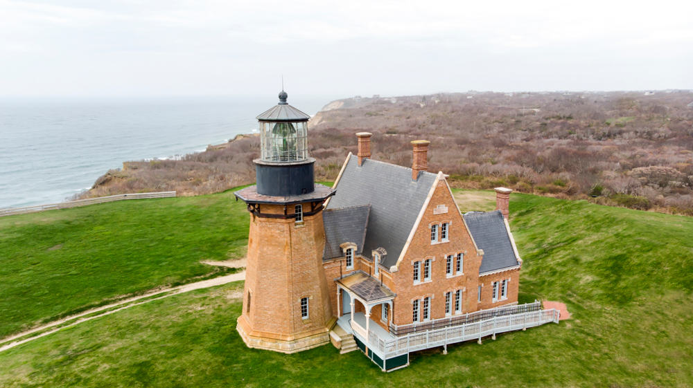 Tan lighthouse adjacent to a lightkeeper\'s house