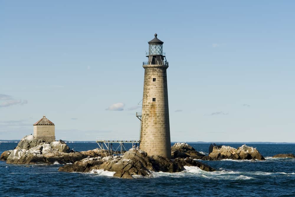 A lighthouse surrounded by water and rocks