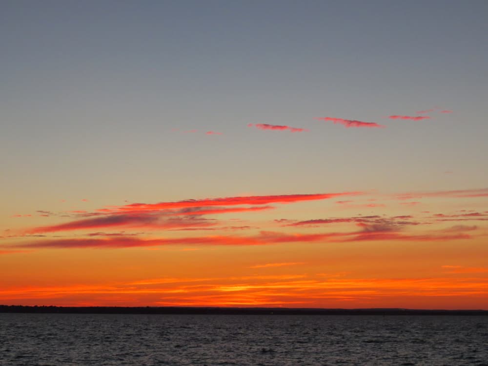 Body of water in front of sunset sky